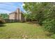Large backyard featuring beautiful trees, a brick home and a well-manicured lawn at 891 Berryman Pl, Lawrenceville, GA 30045