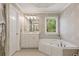 Bright bathroom featuring a large soaking tub, walk-in closet, and large vanity at 891 Berryman Pl, Lawrenceville, GA 30045