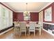 Elegant dining room featuring rich paint, natural light from shuttered windows, and a classic chandelier above the table at 891 Berryman Pl, Lawrenceville, GA 30045