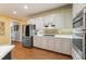 Modern kitchen featuring stainless steel appliances, white cabinets, subway tile backsplash, and hardwood floors at 891 Berryman Pl, Lawrenceville, GA 30045