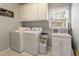 Well-equipped laundry room featuring a washer, dryer, storage cabinets, and a utility sink at 891 Berryman Pl, Lawrenceville, GA 30045
