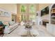 Bright living room with soaring ceilings, large windows, fireplace, built-ins, and plush seating arrangements at 891 Berryman Pl, Lawrenceville, GA 30045