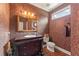 Charming powder room featuring patterned wallpaper, an antique vanity with decorative mirror, and a matching toilet at 891 Berryman Pl, Lawrenceville, GA 30045