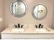 Bathroom with marble countertop, double sinks with matte black fixtures and lighted mirrors at 1384 Allegheny Sw St, Atlanta, GA 30310
