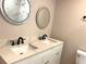 Bathroom with marble countertop, double sinks with matte black fixtures and lighted mirrors at 1384 Allegheny Sw St, Atlanta, GA 30310