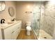 Stylish bathroom featuring double sink vanity, modern fixtures, and glass shower with marble tile at 1384 Allegheny Sw St, Atlanta, GA 30310