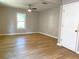 Bedroom with wood floors, neutral walls, one ceiling fan, and a large window for natural light at 1384 Allegheny Sw St, Atlanta, GA 30310