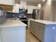 Modern kitchen with stainless appliances, white cabinets, quartz countertops, and a stylish island at 1384 Allegheny Sw St, Atlanta, GA 30310