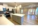 Bright kitchen features stainless steel appliances, herringbone backsplash, and an island with a white countertop at 1384 Allegheny Sw St, Atlanta, GA 30310