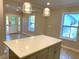 View of kitchen island with modern pendant lights, windows, and entry door in the background at 1384 Allegheny Sw St, Atlanta, GA 30310