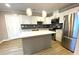Bright kitchen features stainless steel appliances, herringbone backsplash, an island, and white cabinets at 1384 Allegheny Sw St, Atlanta, GA 30310