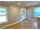 Living room featuring wood floors, lots of natural light from multiple windows, and a glass detailed front door at 1384 Allegheny Sw St, Atlanta, GA 30310