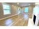 Living room featuring wood floors, a fireplace, multiple windows, and a glass detailed front door at 1384 Allegheny Sw St, Atlanta, GA 30310