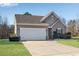 Single-story home with a two-car garage, manicured lawn, and neutral siding under a clear blue sky at 4410 Chaney Ct, Cumming, GA 30028