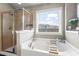 Bright bathroom featuring a luxurious tub, separate shower, and window at 6170 Weddington Dr, Cumming, GA 30040