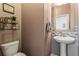 Powder room featuring toilet, sink, and decorative shelves and mirror at 6170 Weddington Dr, Cumming, GA 30040