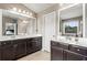 Bright bathroom featuring dual sinks, granite counters, and a large mirror at 6170 Weddington Dr, Cumming, GA 30040
