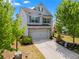 Attractive two-story home featuring a two-car garage, brick accents, and well-landscaped front yard with mature trees at 6170 Weddington Dr, Cumming, GA 30040