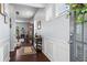 Bright and airy foyer with wood floors, white wainscoting, decorative console table and access to staircase at 6170 Weddington Dr, Cumming, GA 30040
