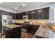 Traditional kitchen with stainless steel appliances, center island, granite counters, and dark wood cabinetry at 6170 Weddington Dr, Cumming, GA 30040