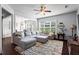 Spacious living room featuring a large sectional sofa, ceiling fan, and open layout to the dining area at 6170 Weddington Dr, Cumming, GA 30040