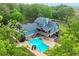 Stunning aerial view of property with large in-ground pool surrounded by lush trees, creating a private oasis at 65 Maude White Rd, Kingston, GA 30145
