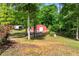 Exterior view of storage building with an additional covered storage shed, set among mature trees at 65 Maude White Rd, Kingston, GA 30145