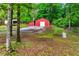 Exterior view of red barn, and covered storage, surrounded by trees at 65 Maude White Rd, Kingston, GA 30145
