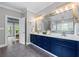 Elegant bathroom featuring double sinks, a large mirror, and blue cabinets providing ample storage space at 65 Maude White Rd, Kingston, GA 30145