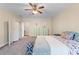 Comfortable bedroom features neutral carpet, ceiling fan, and colorful floral bedding at 65 Maude White Rd, Kingston, GA 30145