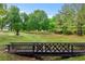 View of wooden bridge surrounded by green trees and lawn at 65 Maude White Rd, Kingston, GA 30145