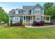 Charming two-story home with manicured lawn, stone accents and inviting front porch with beautiful landscaping at 65 Maude White Rd, Kingston, GA 30145