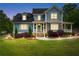 Charming two-story home with manicured lawn, stone accents and inviting front porch with beautiful landscaping at 65 Maude White Rd, Kingston, GA 30145
