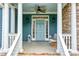 Inviting front porch with stone accents, white columns, and a stylish light blue front door at 65 Maude White Rd, Kingston, GA 30145