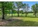 Beautiful grassy lawn framed by tall shade trees and fencing at 65 Maude White Rd, Kingston, GA 30145