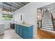 Bright laundry room featuring shiplap walls, herringbone tile floors, and a blue cabinet, adjacent to the main staircase at 65 Maude White Rd, Kingston, GA 30145