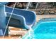 Close-up of a blue swimming pool slide with water flowing into the crystal clear pool at 65 Maude White Rd, Kingston, GA 30145