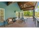 Inviting outdoor patio with comfortable seating and a ceiling fan, offering a serene view of the lush backyard at 65 Maude White Rd, Kingston, GA 30145