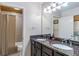 Bathroom featuring granite countertop, double sinks, stylish mirror, and walk-in shower at 1150 Collier Nw Rd # K18, Atlanta, GA 30318