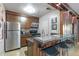 A cozy kitchen featuring stainless steel appliances, a breakfast bar, and wood cabinetry at 1150 Collier Nw Rd # K18, Atlanta, GA 30318