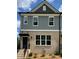 Two-story townhome featuring brick facade and gray siding, complimented by black accents and a well-manicured lawn at 1244 Ainsworth Aly # 41, Sugar Hill, GA 30518