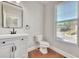 Clean bathroom with white vanity, modern mirror, toilet, and window with natural light at 2919 Camplay Dr, Suwanee, GA 30024