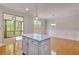 Open kitchen and dining area with a large island, hardwood floors, and screened-in porch access at 2919 Camplay Dr, Suwanee, GA 30024