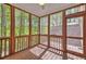 Inviting screened porch with wood floors and walls of screens framing peaceful wooded views at 2919 Camplay Dr, Suwanee, GA 30024