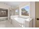 This luxurious bathroom features a shower and tub combo with a scenic view at 3390 Hillshire Dr, Cumming, GA 30028