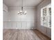 Elegant dining room featuring wood floors, wainscoting, a modern chandelier, and large windows for ample natural light at 3390 Hillshire Dr, Cumming, GA 30028