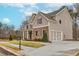 A two-story home with siding and brick accents, showcasing a spacious driveway leading to an attached two-car garage at 3390 Hillshire Dr, Cumming, GA 30028
