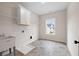 Bright laundry room features a utility sink, storage, and a window for natural light at 3390 Hillshire Dr, Cumming, GA 30028