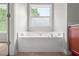 Bathroom with a large bathtub and a frosted window for privacy at 145 Redsage Rdg, Atlanta, GA 30349