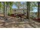 View of the rear exterior, deck, firepit, and grassy backyard with mature trees at 4540 Saddle Se Ct, Smyrna, GA 30082